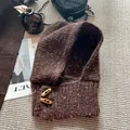 Détail d'une cagoule en maille marron foncé avec boutons en corne et style rétro - Café