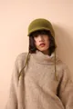 Detail view of grass green ribbed wool beanie with long braided earflaps and front visor - Green