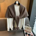 Detail of white knit sweater paired with a brown wool shawl featuring decorative pom-poms - Coffee Khaki
