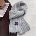 Close-up of grey chunky knit scarf with premium ribbed texture and navy woven patch detail - Light Gray