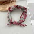 Detail eines salbeigrünen Blumenschals mit hochwertigen Nähten und geknoteter Textur - Rot