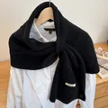 Classic black knitted button scarf for women styled over a white long sleeve shirt - Black