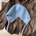 Détail à plat d'un bonnet en laine bleu clair avec protège-oreilles sur cuir - Bleu