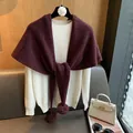 Detail of burgundy knit wool shawl with pom-pom accents on a white sweater - Wine Red & Grey