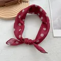 Gros plan d'un foulard en soie rouge à pois ondulés blancs sur un plateau en bois décor - 58*58cm / Rouge