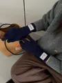 Detail of navy blue knit glove with branded white woven label on the wrist cuff - Navy Blue
