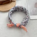 Macro shot of bordeaux cotton linen paisley bandana scarf tied in a decorative knot - Orange Border
