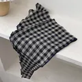 Black and white plaid triangular scarf with ruffled edges on a natural stone surface - Large Plaid Black