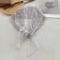 Detail van een elegante semi-transparante sjaal met witte madeliefjes op grijze stof - Oudroze
