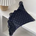 Detail view of navy blue polka dot linen scarf featuring delicate ruffled edges on a table - Polka Dot Navy Blue