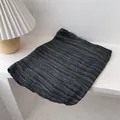 Detail of soft charcoal crinkle texture scarf draped over minimalist white steps - Black