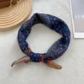 Detail of vintage navy blue paisley bandana with silky texture and elegant knot styling - Ginger Edge