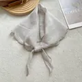 Primer plano de pañuelo triangular de lino beige con bordes festoneados y detalle de nudo - Blanco Roto