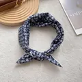 Détail d'un bandeau bleu marine à motif cachemire avec nœud sur support en bois - 58x58 / Bleu marine