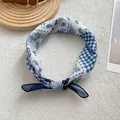 Macro view of blue paisley and checkered pattern fabric on a stylish knotted headscarf - Blue and White Paisley Patchwork / Blue