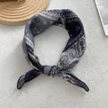Close-up of vintage paisley cotton linen silk scarf tied in a knot on white surface - 58x58cm / Black