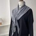 Gray knitted triangle shawl with ribbed texture draped over a black blazer for styling - Gray