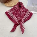 Detail of burgundy floral square scarf with geometric border on soft background - 70cmx70cm / Red