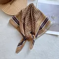 Macro detail of silk square scarf showing brown geometric chain patterns and smooth texture - Ginger Yellow