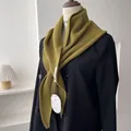 Detailed macro view of olive green ribbed knit triangle shawl with original design tag - Olive Green