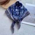 Detailopname van zijden sjaal met paisley-motief bij bruine tas op wit tapijt - Donkerblauw met Grijze Rand / Blauw