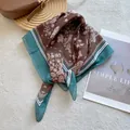 Macro detail of paisley square scarf with floral pattern and teal striped border - Coffee