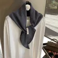 Eleganter dunkelgrauer Wollschal mit Lochstrickmuster über einem weißen Oberteil gezeigt - Grau