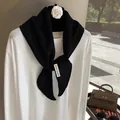 Detail shot of the care label showing 92% wool and 8% cashmere blend on black knit scarf - Black