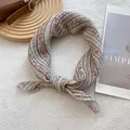 Detail of floral cotton linen headscarf tied in a bow on a vintage leather bag background - 70x70cm / Beige Grille