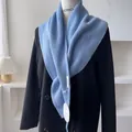 Detailed knit texture of light blue triangular shawl with woven label and tag - Light Blue