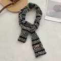 Detail van de gebreide textuur van de Fair Isle-sjaal met bruin lederen labelaccent - Zwart