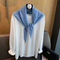 Detailaufnahme der Strickstruktur des himmelblauen Wolldreieckstuchs am Bügel - Hellblau