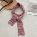 Detailopname van retro gebreide sjaal met golfpatroon en bruin lederen merklabel erop - Roze
