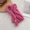 Dettaglio di una sciarpa sottile in maglia rosa con etichetta in tessuto egg. - Rosa Lampone