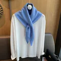 Sky blue 100% wool knitted scarf with metal logo accent over a white shirt - Light Blue