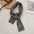 Detail van Fair Isle gebreide sjaal met blauw en oranje golfpatronen en een lederen merklabel - Grijs