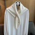 Detail showing the white knitted wool scarf texture and wrap styling on a simple top - Off White