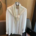 Detail view of cream white knitted shawl with metal buckle and soft cotton long sleeve tee - Cream Rice