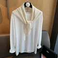 Detail der Strickstruktur und Kamelien-Bügel des cremefarbenen Wollstrick-Schals - Gebrochenes Weiß