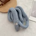 Dettaglio di sciarpa in maglia celeste con etichetta egg e trama di filato spesso - Grigio
