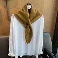 Close-up of ginger yellow wool knit scarf paired with a minimalist white cotton tee - Ginger Yellow