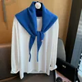 Detailansicht eines königsblauen Strickschals aus Wolle mit weißem Langarmshirt - Blau