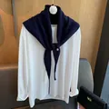 Nahaufnahme eines marineblauen Wollschals mit Metallknopf über einem weißen T-Shirt - Marineblau