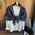 Close-up of a blue and white paisley pattern triangular shawl over a white top - Navy Blue