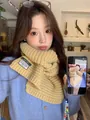 Close-up of yellow chunky knit scarf with exclusive design tag on blue cardigan - Light Yellow