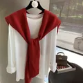 Detailed view of dark red knitted shawl paired with a classic white cotton long sleeve top - Red