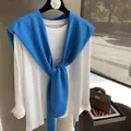 Detail of a cobalt blue knit shawl draped over a classic white long sleeve t-shirt - Sea Salt Blue