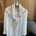 Detailed close-up of hollowed-out diamond pattern on this beige wool knit shawl scarf - Off White