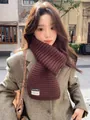 Detail of dark brown chunky knit scarf with white woven label on grey herringbone coat - Cocoa Brown