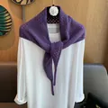 Gros plan sur une écharpe triangle en laine violette avec des détails de tricot ajouré - Violet